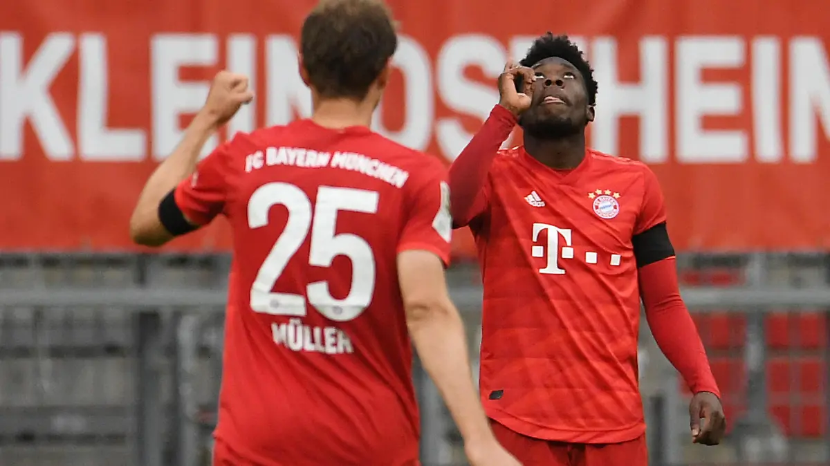 23.05.2020, Bayern, München: Fußball: Bundesliga, 27. Spieltag, FC Bayern München - Eintracht Frankfurt, in der Allianz Arena. Alphonso Davies (r) von Bayern jubelt über sein Tor zum 4:2 mit Thomas Müller. Foto: Andreas Gebert/Reuters-Pool/dpa - WICHTIGER HINWEIS: Gemäß den Vorgaben der DFL Deutsche Fußball Liga bzw. des DFB Deutscher Fußball-Bund ist es untersagt, in dem Stadion und/oder vom Spiel angefertigte Fotoaufnahmen in Form von Sequenzbildern und/oder videoähnlichen Fotostrecken zu verwerten bzw. verwerten zu lassen. +++ dpa-Bildfunk +++