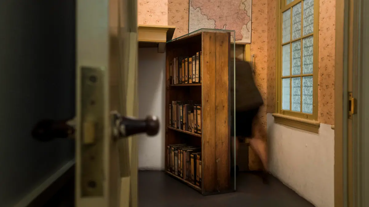FILE- A woman enters the secret annex at the renovated Anne Frank House Museum in Amsterdam, Netherlands, Wednesday, Nov. 21, 2018. A cold case team that combed through evidence for five years may have solved one of World War II's enduring mysteries: Who betrayed Jewish teenage diarist Anne Frank and her family ? Their answer, outlined in a new book, is that it most likely was a Jewish lawyer called Arnold van den Bergh. (AP Photo/Peter Dejong, File)