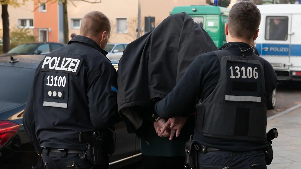07.11.2018, Berlin: Polizeibeamte führen mit Handschellen einen festgenommenen Mann nach einer Razzia in einem Wohnhaus in Tempelhof ab. Der Einsatz in der Ullsteinstraße richtete sich gegen kriminelle Mitglieder von arabischstämmigen Clans. (zu dpa "Razzia gegen Clans - Polizei nimmt Verdächtigen in Tempelhof fest" vom 07.11.2018) Foto: Paul Zinken/dpa +++ dpa-Bildfunk +++