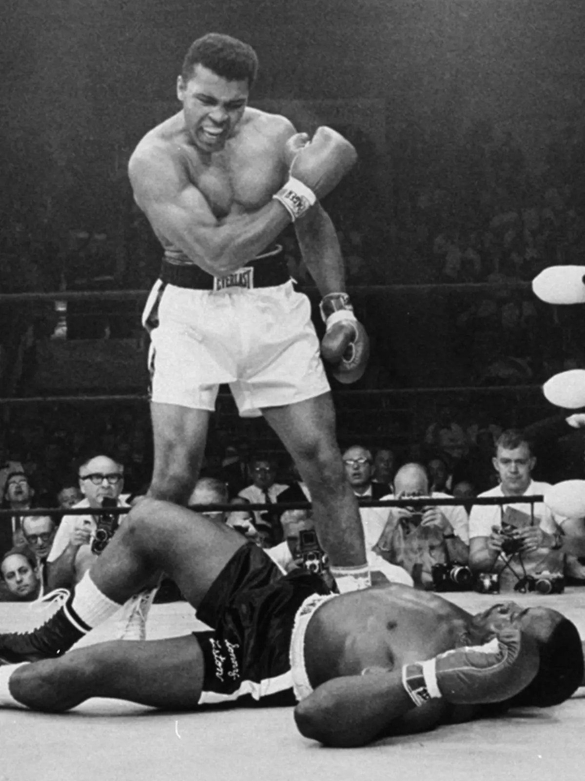 FILE - In this May 25, 1965, file photo, heavyweight champion Muhammad Ali stands over fallen challenger Sonny Liston, shouting and gesturing shortly after dropping Liston with a short hard right to the jaw in the first round of their title fight in Lewiston, Maine. The bout produced one of the strangest finishes in boxing history as well as one of sports¿ most iconic moments. (AP Photo/John Rooney, File) |