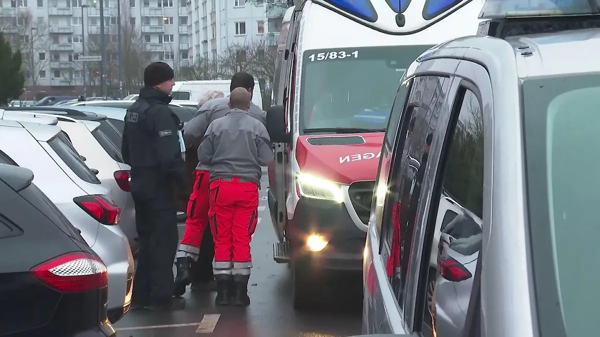 Notfallsanitäter bringen das zweite Opfer in den Rettungswagen. Der Mann (nicht zu sehen) war offenbar kurz nach der Frau angegriffen worden. Die Polizei prüft, ob es ein und derselbe Täter war.