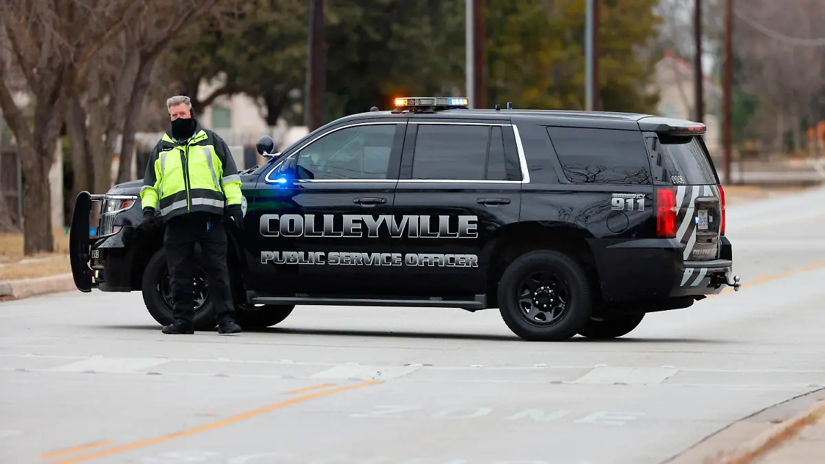 CORRECTS BYLINE TO ELIAS VALVERDE INSTEAD OF LYNDA M. GONZALEZ - A police officer blocks a street near Congregation Beth Israel in Colleyville, Texas on Saturday afternoon, Jan. 15, 2022. Authorities said a man took hostages Saturday during services at the synagogue where the suspect could be heard ranting in a livestream and demanding the release of a Pakistani neuroscientist who was convicted of trying to kill U.S. Army officers in Afghanistan. (Elias Valverde/The Dallas Morning News via AP)