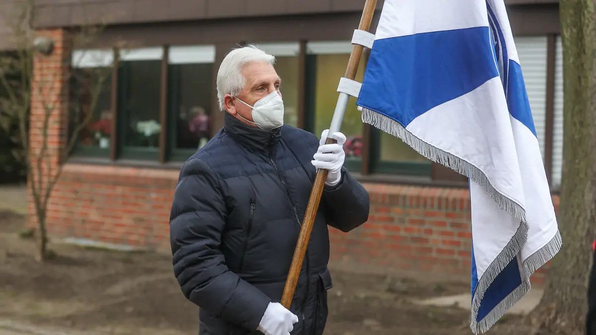 15.01.2022, Nordrhein-Westfalen, Gelsenkirchen: Schalkes Klaus Fischer trägt die Vereinsfahne auf dem Weg zum Grab von Reinhard Libuda. Nach dem Ende der Liegezeit von 25 Jahren erhält der frühere Schalker Stürmer Reinhard «Stan» Libuda nun doch eine neue letzte Ruhestätte auf dem Fan-Feld. Foto: Tim Rehbein/dpa +++ dpa-Bildfunk +++