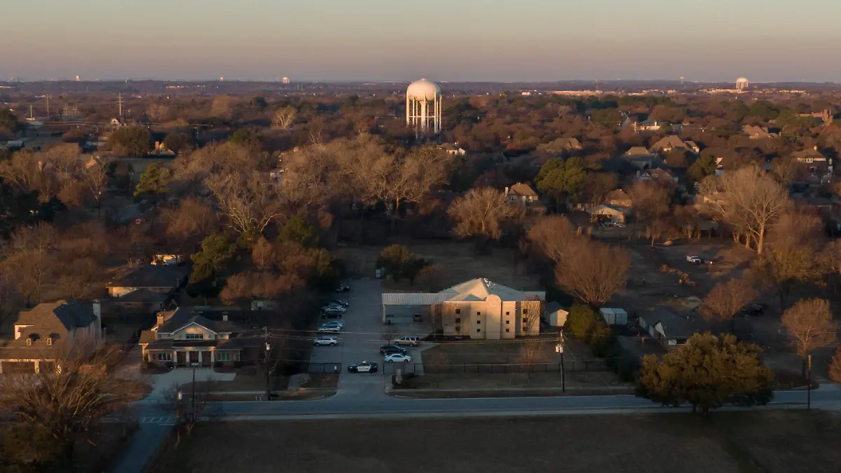 An aerial view of police standing in front of the Congregation Beth Israel synagogue, Sunday, Jan. 16, 2022, in Colleyville, Texas. A man held hostages for more than 10 hours Saturday inside the temple. The hostages were able to escape and the hostage taker was killed. FBI Special Agent in Charge Matt DeSarno said a team would investigate "the shooting incident." (AP Photo/Brandon Wade)