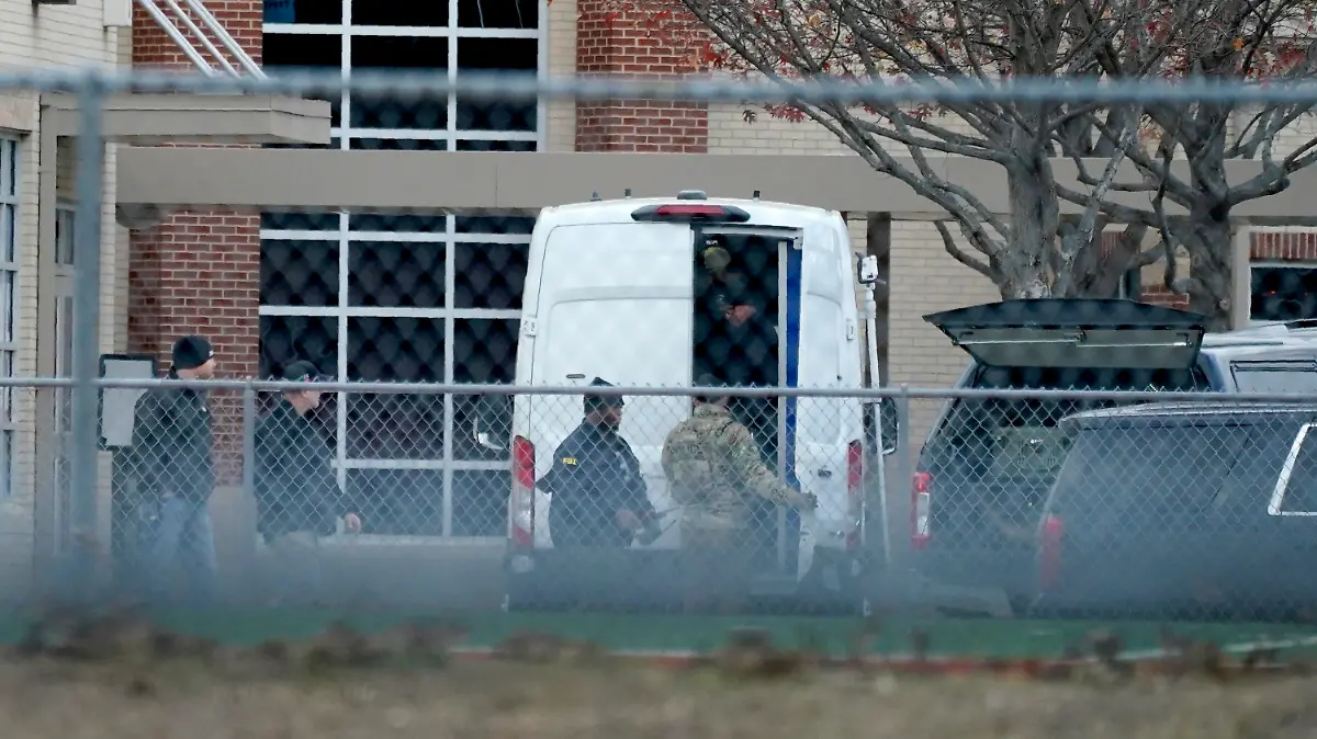 Law enforcement officials gather at Colleyville Elementary School near the Congregation Beth Israel synagogue on Saturday, Jan. 15, 2022 in Colleyville, Texas. Authorities said a man took hostages Saturday during services at the synagogue where the suspect could be heard ranting in a livestream and demanding the release of a Pakistani neuroscientist who was convicted of trying to kill U.S. Army officers in Afghanistan. (AP Photo/Tony Gutierrez)
