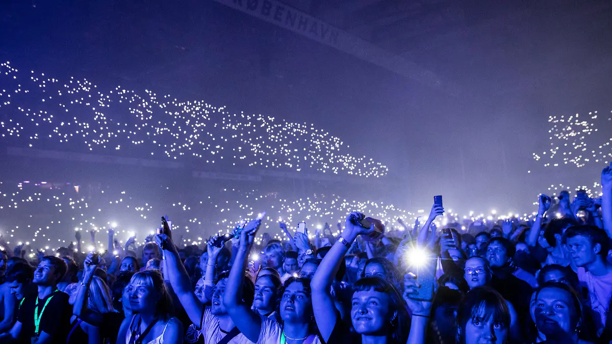 10.09.2021, Dänemark, Kopenhagen: Das Publikum hört den "Minds of 99" während eines Konzerts im Park zu. Die dänische Rockband hatte ein Konzert vor zehntausenden Fans gespielt und damit die pandemiebedingt fast vergessene Zeit großer Stadionkonzerte wiederaufleben lassen. (zu dpa Ohne Corona-Auflagen: 50 000 Zuschauer bei Konzert in Kopenhagen) Foto: Olafur Steinar Gestsson/Ritzau Scanpix/AP/dpa +++ dpa-Bildfunk +++