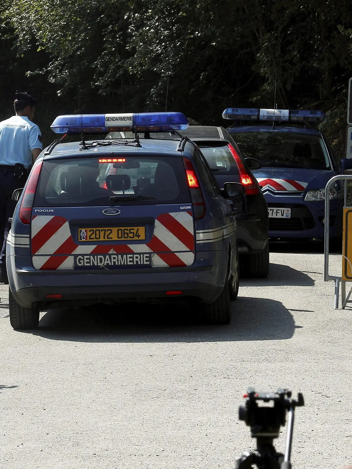 epa03389457 Police cars and officers block reporters and photographers gathered on a road leading to a car park near a camp site in Chevaline near the Annecy Lake, France, 08 September 2012. French prosecutors launched a formal murder investigation Friday over the killings of three members of a British family and a French cyclist in the Alps, and said they were exploring a possible family row over money. EPA/NORBERT FALCO/LE DAUPHINE ---FRANCE OUT---  +++(c) dpa - Bildfunk+++