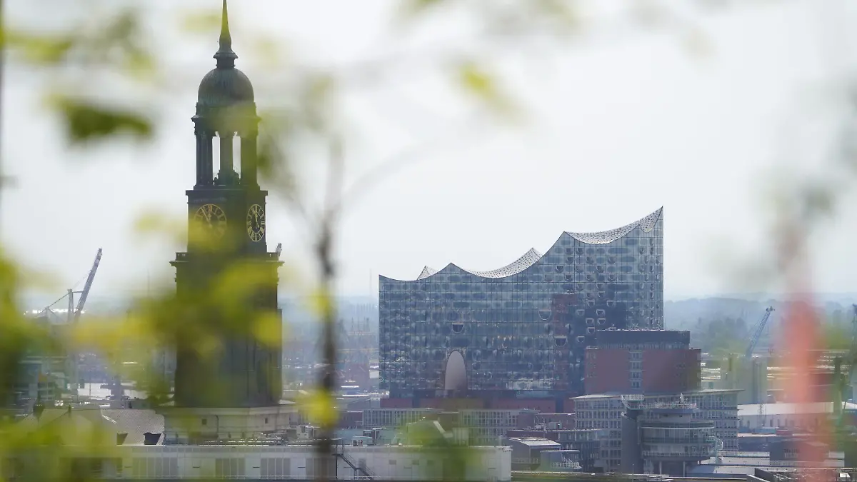 PRODUKTION - 22.05.2023, Hamburg: Blick vom Hochbunker auf die Elbphilharmonie in der Hafencity. Links im Bild ist die Hauptkirche Sankt Michaelis (Michel) zu sehen. Am 23.05.2023 wird der neue Spielplan der Elbphilharmonie und Laeiszhalle vorgestellt. Foto: Marcus Brandt/dpa +++ dpa-Bildfunk +++