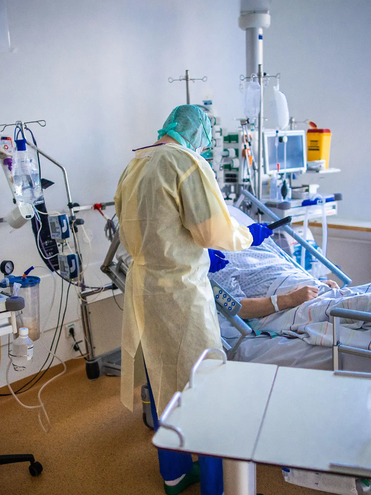 ARCHIV - 23.11.2020, Mecklenburg-Vorpommern, Greifswald: Eine Pflegekraft betreut im besonders geschützten Teil der Intensivstation des Universitätsklinikums Greifswald einen Corona-Patienten. Die Zahl der Todesfälle und der Neuinfektionen mit dem Coronavirus bleibt auf hohem Niveau. Die deutschen Gesundheitsämter haben dem Robert Koch-Institut (RKI) 19 528 neue Fälle und 731 Todesfälle binnen eines Tages übermittelt, wie das RKI am Dienstag (22.12.2020) bekanntgab. Foto: Jens Büttner/dpa-Zentralbild/dpa +++ dpa-Bildfunk +++