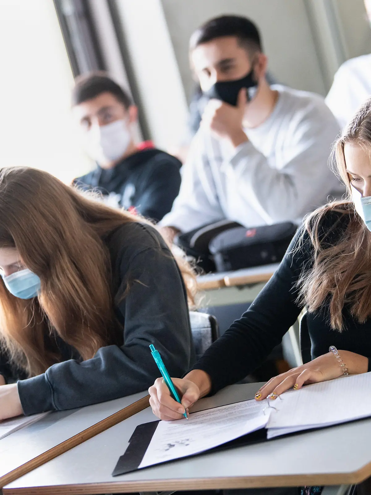 ARCHIV - 17.11.2020, Bayern, München: Schülerinnen und Schüler nehmen mit Mund- und Nasenschutz am Unterricht in einem Geographie-Seminar in der Jahrgangsstufe elf teil. Auch ab Herbst wird die Maske im Unterricht wieder notwendig sein.      (zu dpa «Und wieder Corona-Schule: Von Lüftern, Tests und Kindern aus der Spur») Foto: Matthias Balk/dpa +++ dpa-Bildfunk +++