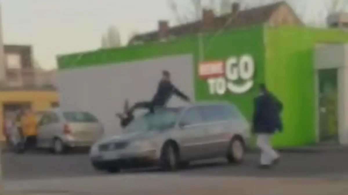 Mann fährt mit anderem Mann auf dem Dach.