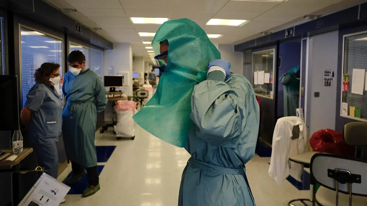 12.01.2022, Spanien, Pamplona: Ein medizinischer Mitarbeiter zieht sich Schutzkleidung auf der Intensivstation der «Clinica Universitaria» an. Foto: Alvaro Barrientos/AP/dpa +++ dpa-Bildfunk +++