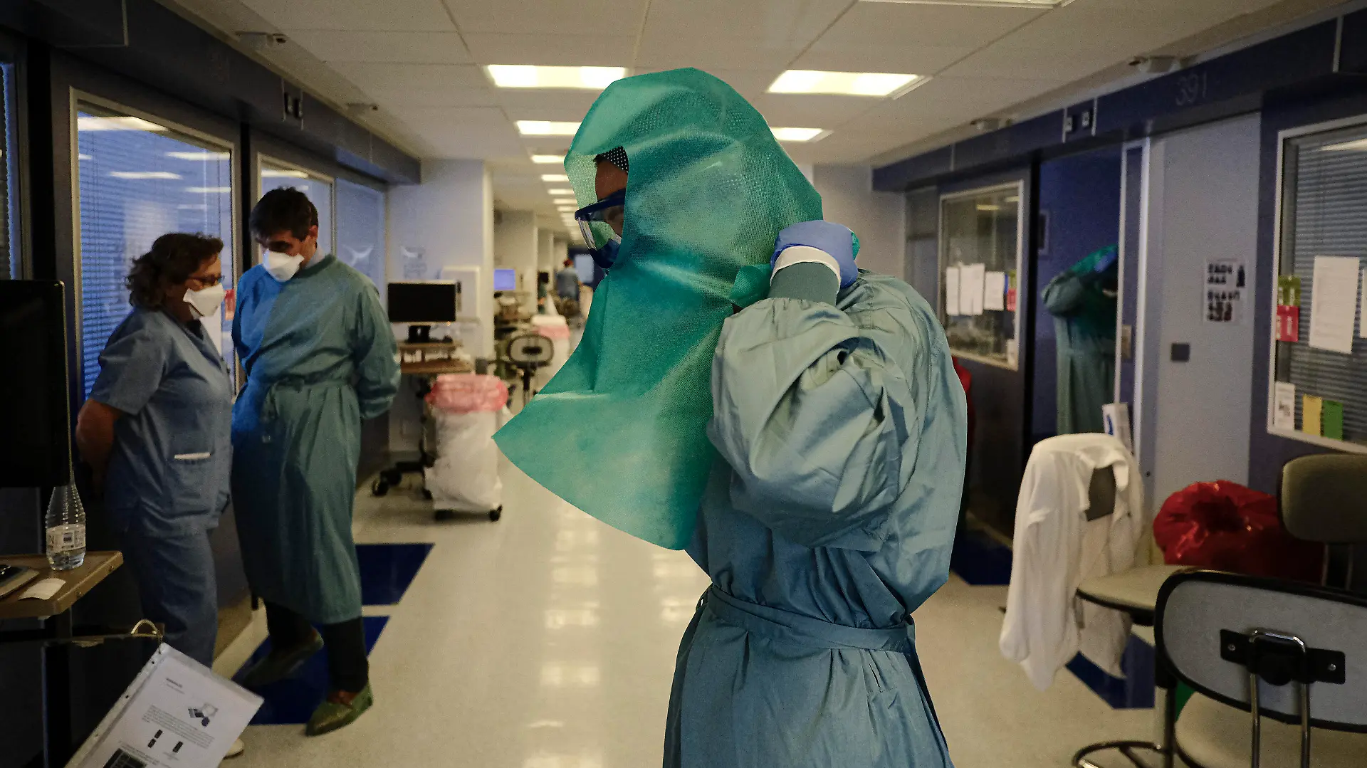 12.01.2022, Spanien, Pamplona: Ein medizinischer Mitarbeiter zieht sich Schutzkleidung auf der Intensivstation der «Clinica Universitaria» an. Foto: Alvaro Barrientos/AP/dpa +++ dpa-Bildfunk +++