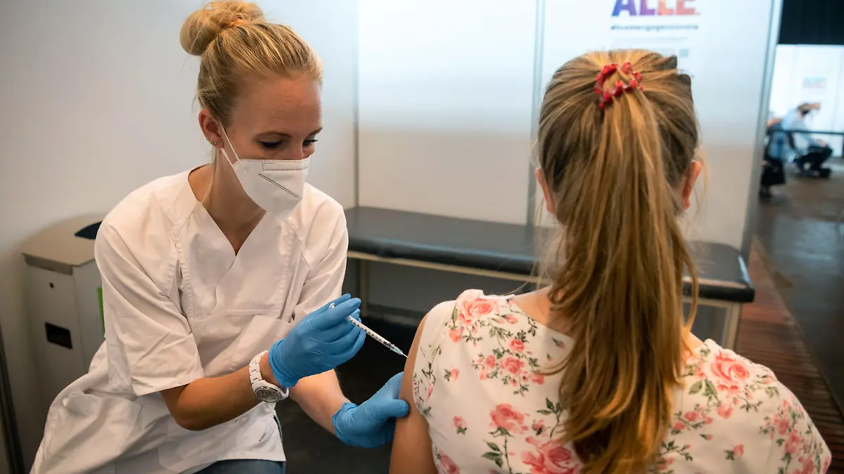 06.08.2021, Bremen: Die 15-jährige Clara wird im Impfzentrum geimpft. In Bremen können sich Kinder über 12 Jahre gegen Corona impfen lassen. Foto: Sina Schuldt/dpa +++ dpa-Bildfunk +++