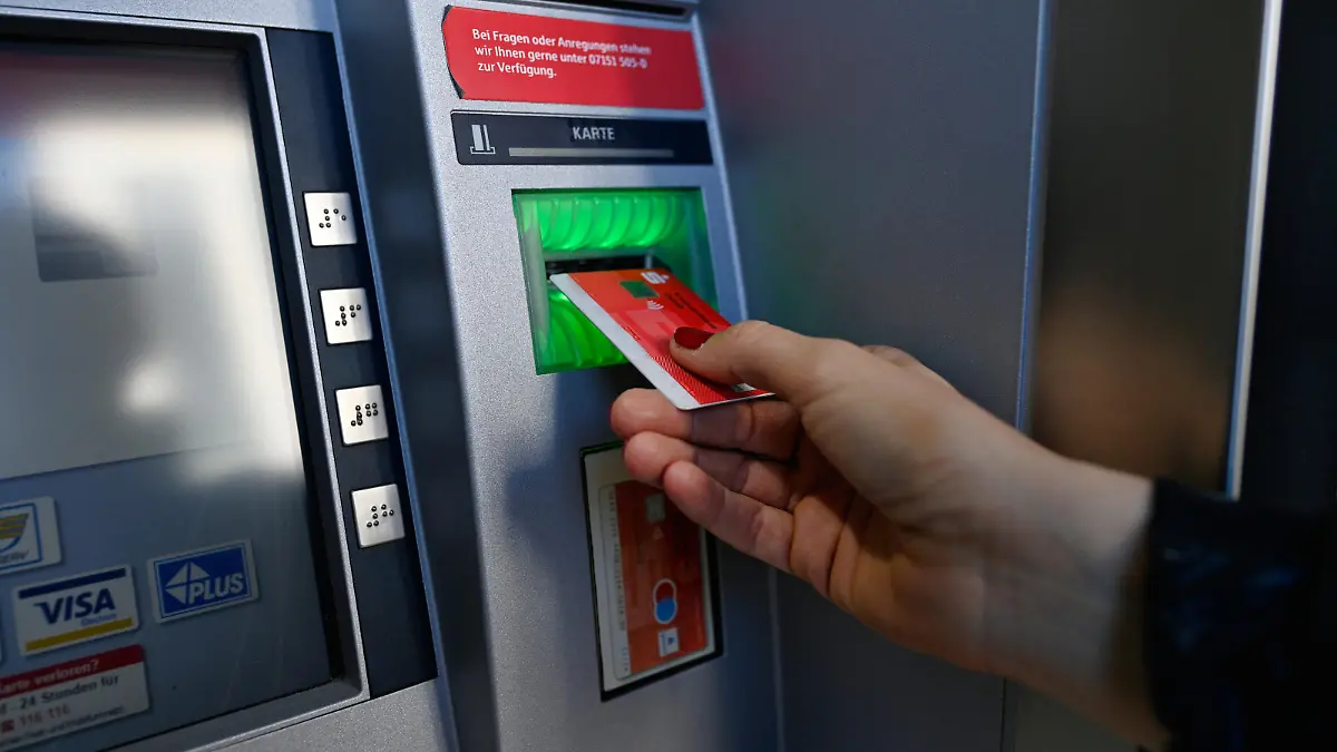 Frau führt ec-Karte am Geldautomat einer Sparkasse ein, Waiblingen, Baden-Württemberg, Deutschland