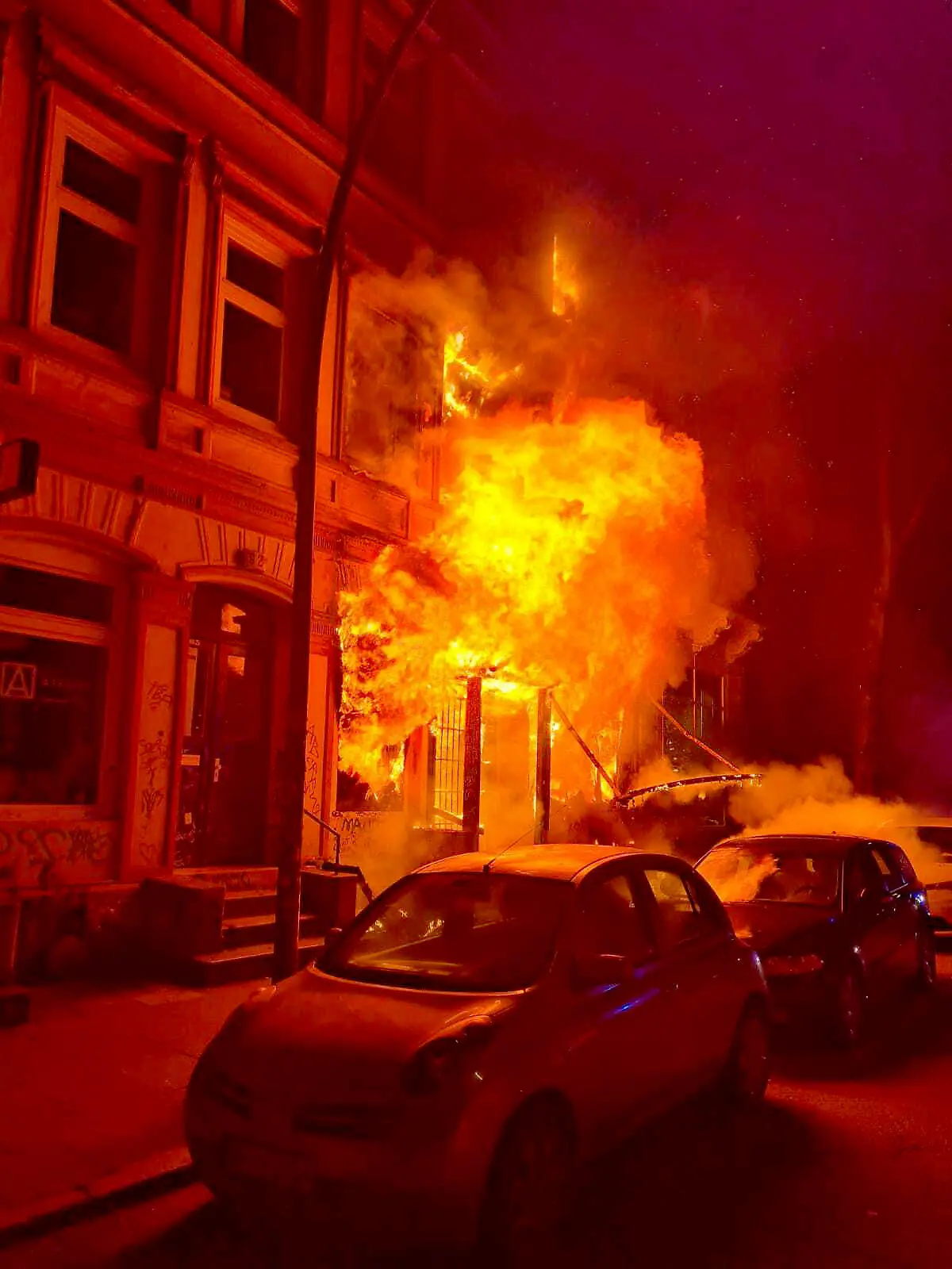 12.01.2022, Hamburg: Flammen schlagen aus einem Haus in St. Pauli. Ein Brand eines Mehrfamilienhauses in Hamburg-St. Pauli hat für einen größeren Einsatz der Feuerwehr gesorgt. Zwei Menschen seien bei dem Brand leicht verletzt worden. Der Feuerwehr zufolge handelt es sich bei dem Wohn- und Geschäftshaus um ein viergeschossiges Gebäude mit einer Bar im Erdgeschoss. (Bestmögliche Qualität) Foto: ---/TNN/dpa +++ dpa-Bildfunk +++