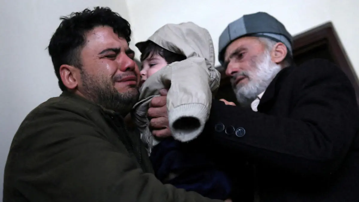 Hamid Safi, a 29-year-old taxi driver who had found baby Sohail Ahmadi in the airport, cries as he hands over Sohail to his grandfather Mohammad Qasem Razawi in Kabul, Afghanistan, January 8, 2022. Picture taken January 8, 2022. REUTERS/Ali Khara TPX IMAGES OF THE DAY