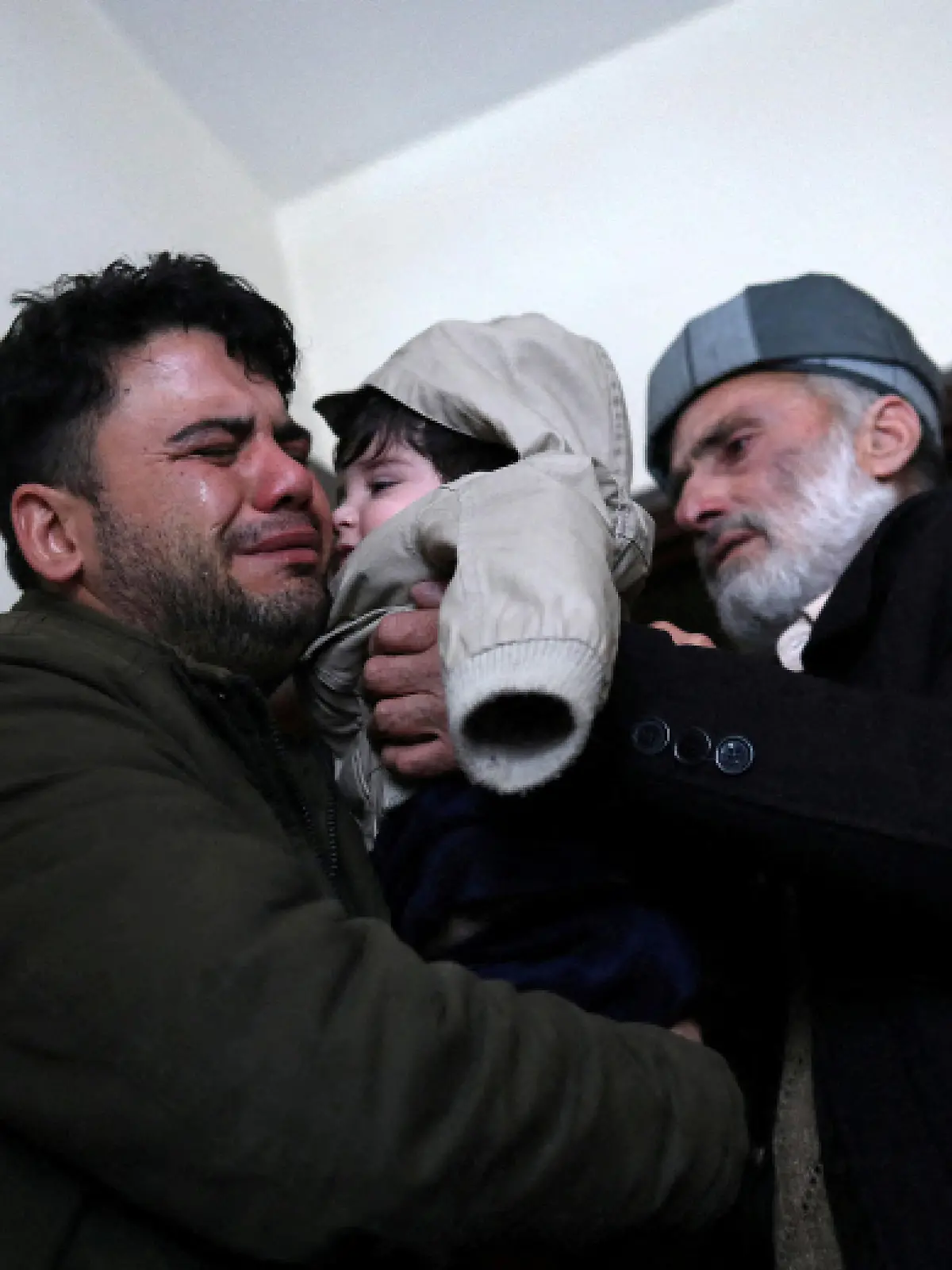 Hamid Safi, a 29-year-old taxi driver who had found baby Sohail Ahmadi in the airport, cries as he hands over Sohail to his grandfather Mohammad Qasem Razawi in Kabul, Afghanistan, January 8, 2022. Picture taken January 8, 2022. REUTERS/Ali Khara     TPX IMAGES OF THE DAY
