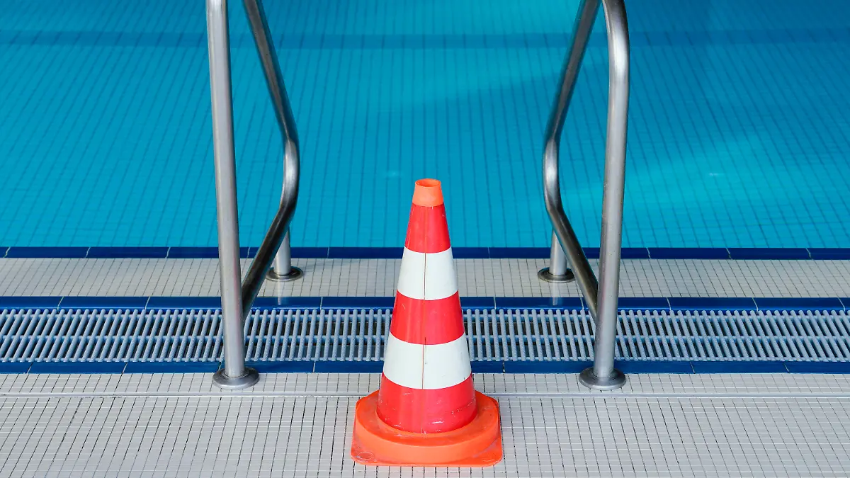 ARCHIV - 16.03.2020, Baden-Württemberg, Heidelberg: Eine Pylone steht im Hallenbad Köpfel an einer Leiter des Schwimmerbeckens. Das Schwimmbad ist wegen der Coronakrise bis auf weiteres geschlossen. (Zu dpa «Verband: Hallenbäder im Sommer für Anfängerschwimmen öffnen») Foto: Uwe Anspach/dpa +++ dpa-Bildfunk +++