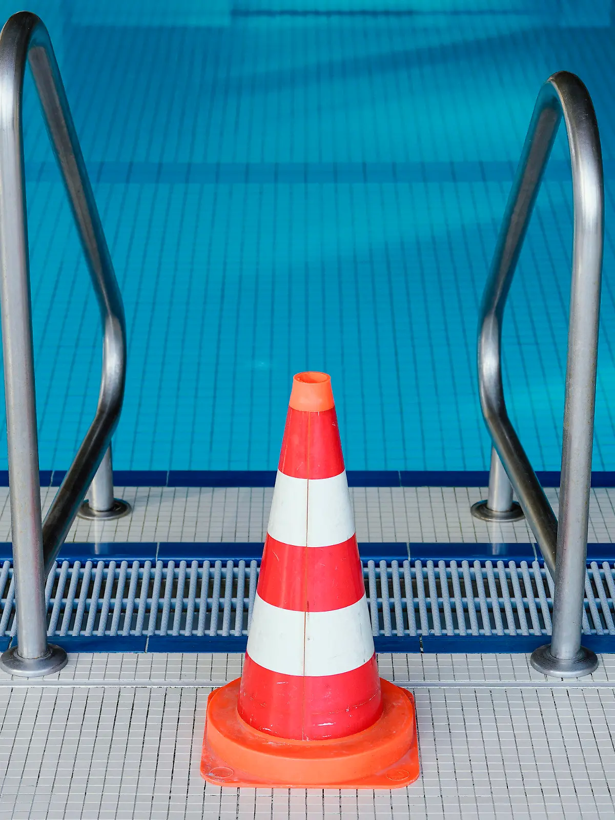 ARCHIV - 16.03.2020, Baden-Württemberg, Heidelberg: Eine Pylone steht im Hallenbad Köpfel an einer Leiter des Schwimmerbeckens. Das Schwimmbad ist wegen der Coronakrise bis auf weiteres geschlossen. (Zu dpa «Verband: Hallenbäder im Sommer für Anfängerschwimmen öffnen») Foto: Uwe Anspach/dpa +++ dpa-Bildfunk +++
