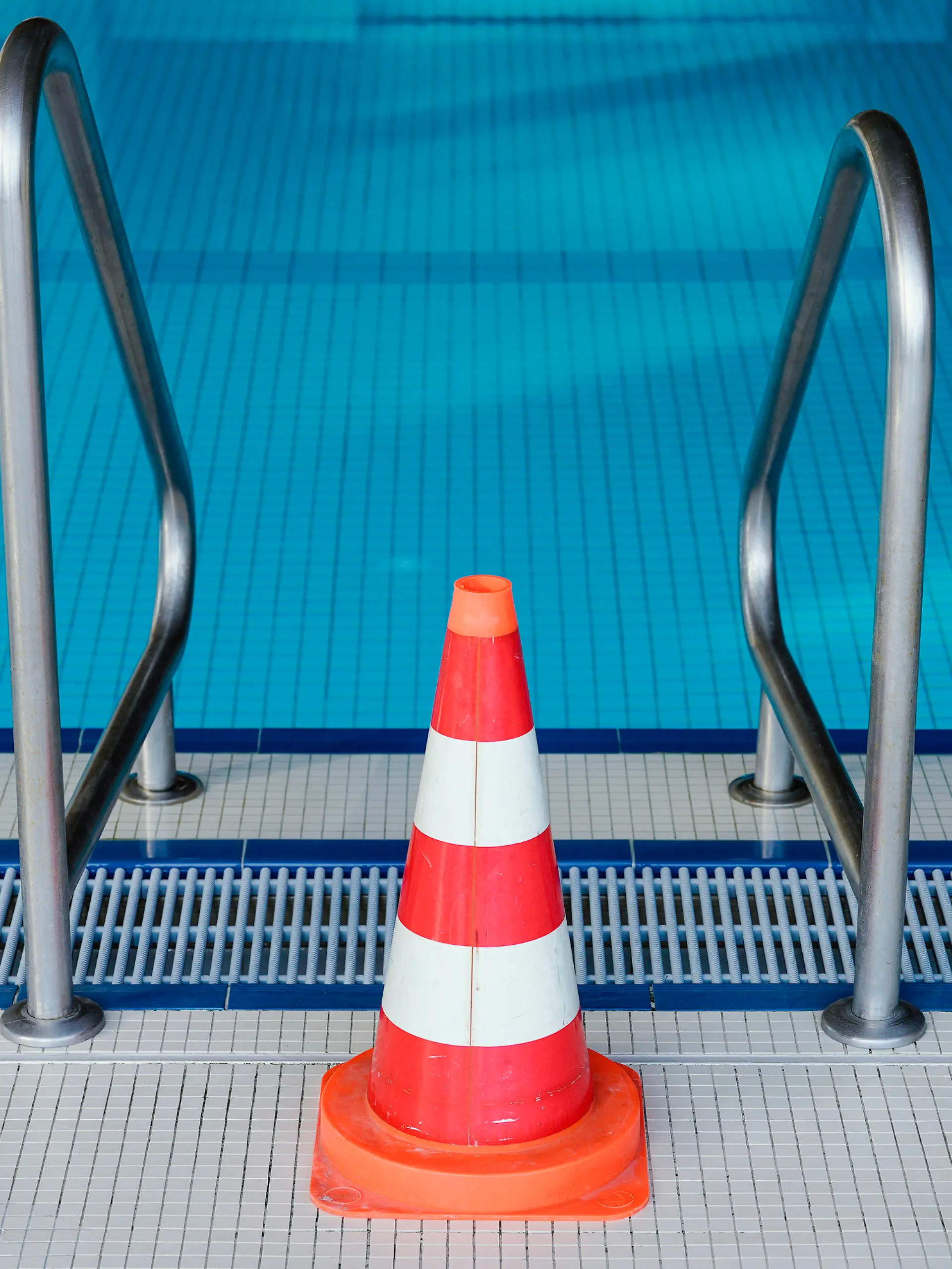 ARCHIV - 16.03.2020, Baden-Württemberg, Heidelberg: Eine Pylone steht im Hallenbad Köpfel an einer Leiter des Schwimmerbeckens. Das Schwimmbad ist wegen der Coronakrise bis auf weiteres geschlossen. (Zu dpa «Verband: Hallenbäder im Sommer für Anfängerschwimmen öffnen») Foto: Uwe Anspach/dpa +++ dpa-Bildfunk +++