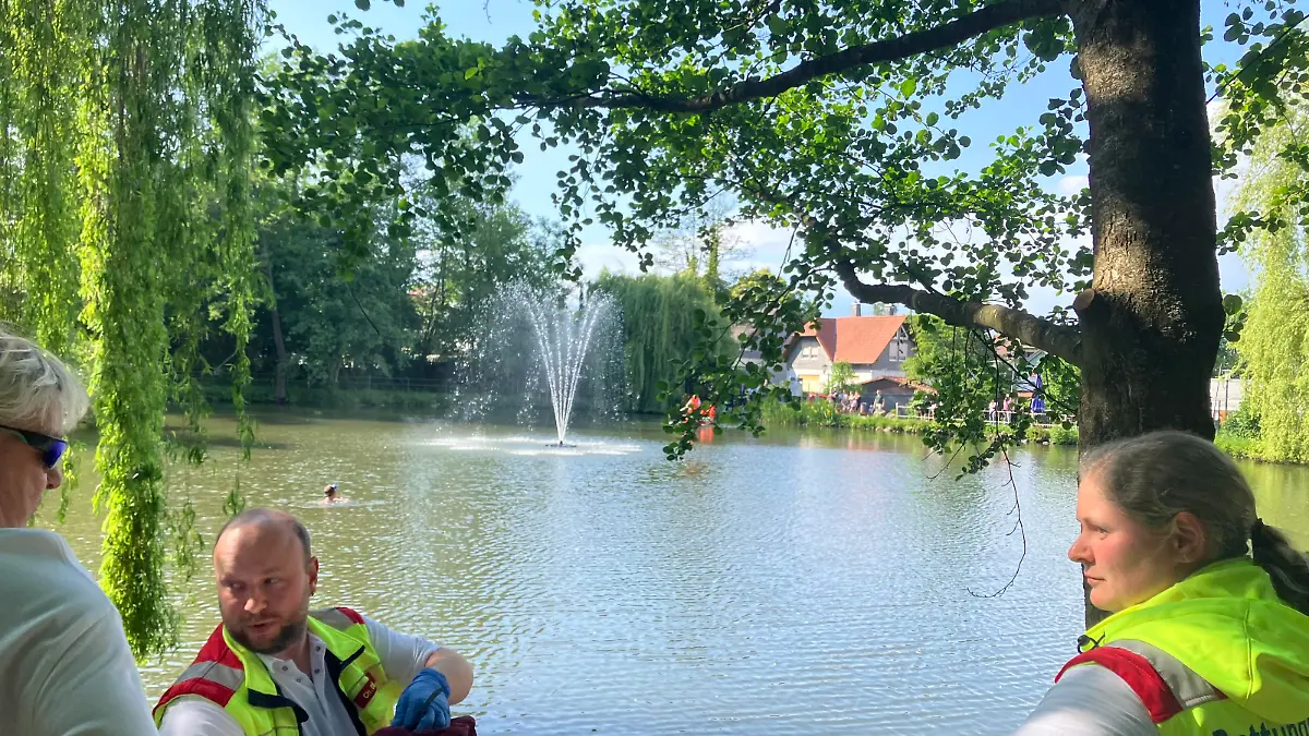 Einsatz der Feuerwehr: Ein Junge steht auf dem Stein im Wasser, welches ihm bis zum Hals steht