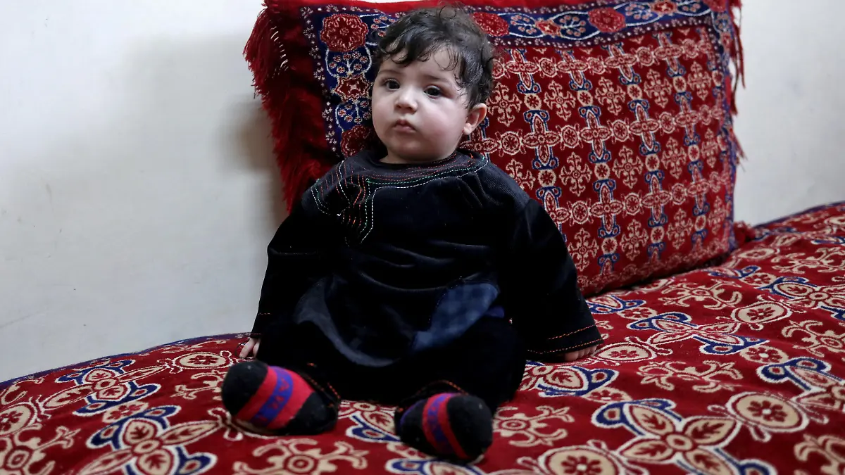 Baby Sohail Ahmadi sits inside the house of Hamid Safi, a taxi driver who had found Sohail in the airport, in Kabul, Afghanistan, January 7, 2022. Picture taken January 7, 2022. REUTERS/Ali Khara