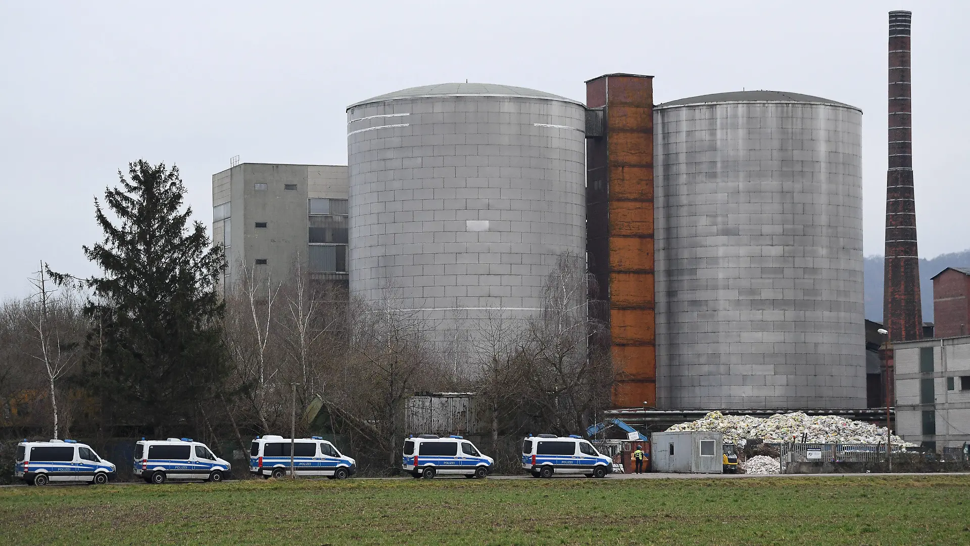 12.01.2022, Niedersachsen, Northeim: Einsatzfahrzeuge der Polizei stehen vor der ehemaligen Zuckerrübenfabrik. Zwei bewaffnete Männer sind nach einem Überfall in Höckelheim auf eine Sparkasse flüchtig. Foto: Swen Pförtner/dpa +++ dpa-Bildfunk +++