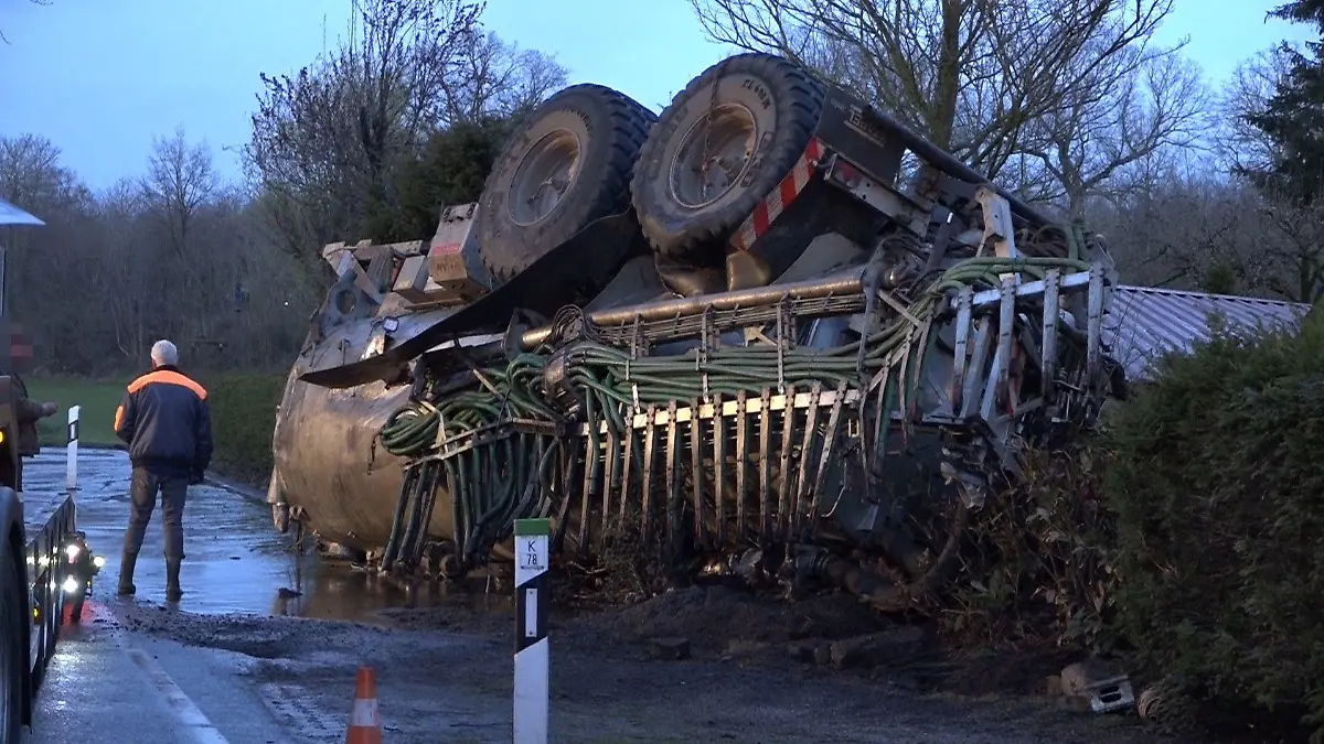 07.04.2021, Nordrhein-Westfalen, Horstmar: Nach einem Unfall liegt ein Trakor mit geladener Gülle auf dem Dach. Bildern zufolge ist der Anhänger des Traktors auf ein Carport gekippt und die Gülle ist ausgelaufen. Foto: Tebben/NWM-TV/dpa +++ dpa-Bildfunk +++