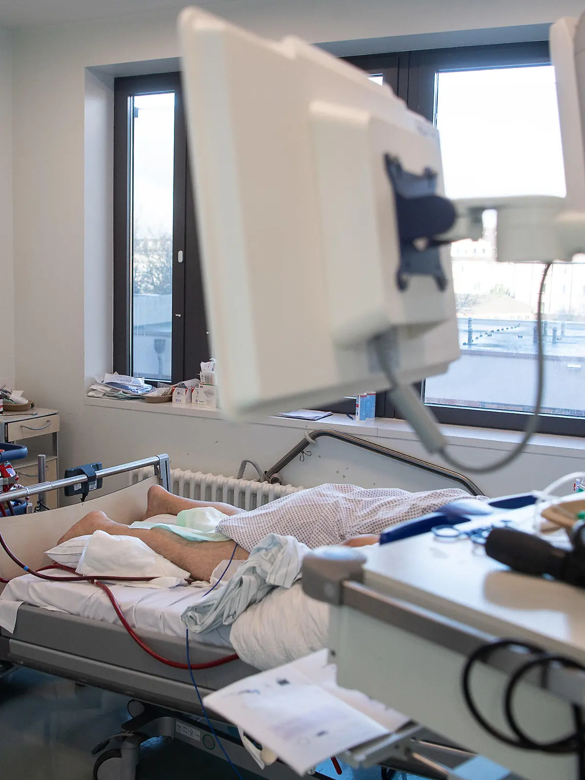 05.01.2022, Hessen, Offenbach am Main: Die Schläuche einer ECMO-Maschine auf der Intensivstation für Corona-Patienten am Sana Klinikum Offenbach führen zu einem Patienten. Bei dem Verfahren übernimmt eine Maschine die Funktion der Lunge und tauscht Sauerstoff sowie Kohlenstoffdioxid im Blut des Patienten aus. Auf der Corona-Intensivstation sind momentan alle Betten bis auf zwei belegt. Die Coronainfektionszahlen im Rhein-Main-Gebiet steigen jedoch wieder an. Foto: Sebastian Gollnow/dpa +++ dpa-Bildfunk +++