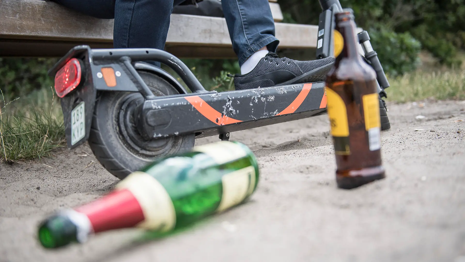 ILLUSTRATION - Ein Mann sitzt am 10.07.2019 alkoholisiert vor einem gemieteten E-Tretroller in Berlin (gestellte Szene). Foto: Robert Guenther || Modellfreigabe vorhanden