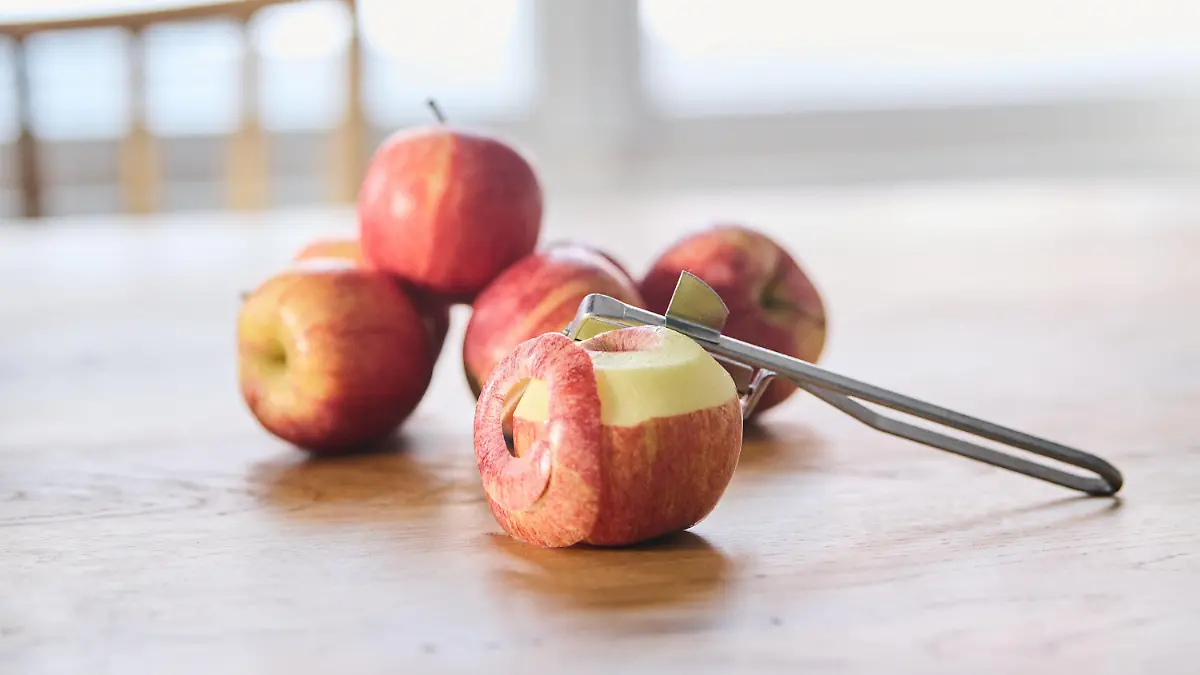 PRODUKTION - 03.01.2022, Berlin: Ein halb geschälter Apfel liegt vor weiteren Äpfeln auf einem Tisch. (gestellte Szene) Am 11. Januar ist der Tag des deutschen Apfels. (Zu dpa: "Manch ein Biss mit Folgen: Was den Apfel so bedeutend macht") Foto: Annette Riedl/dpa +++ dpa-Bildfunk +++