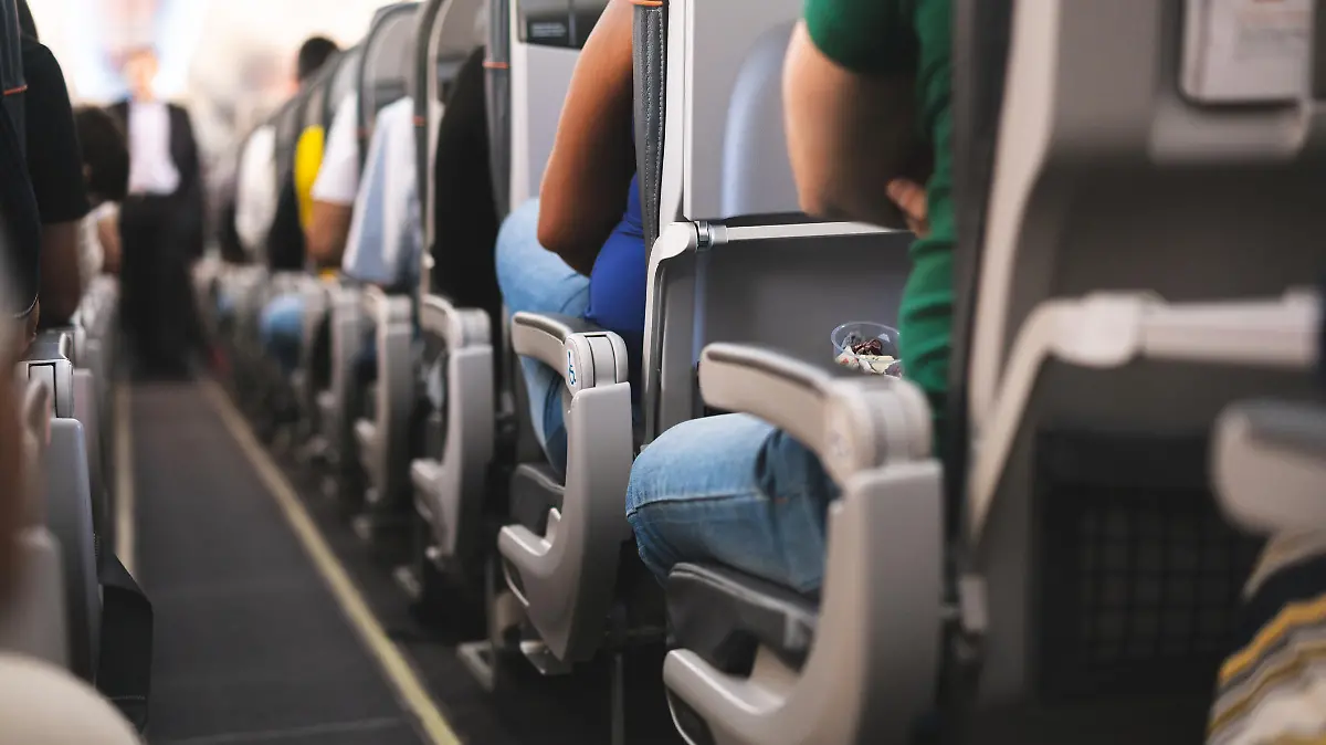 Ein Gang im Flugzeug mit Sitzen und Passagieren