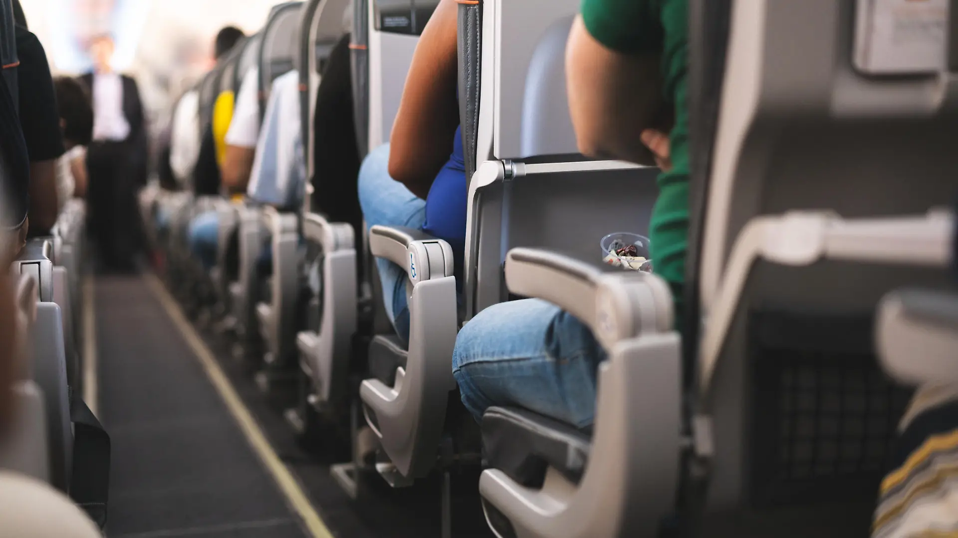 Ein Gang im Flugzeug mit Sitzen und Passagieren