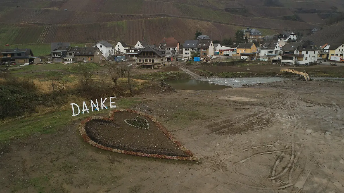27.12.2021, Rheinland-Pfalz, Dernau: Mit einem herzförmigen Blumenbeet und einem Schriftzug "Danke" dahinter danken die Bewohner den Fluthelfern (Aufnahme mit einer Drohne). Fast ein halbes Jahr nach dem Hochwasser im Ahrtal müssen immer noch viele Flutopfer in Ausweichquartieren ausharren. (zu dpa-Korr "Hoffen auf Wiederaufbau - Ahrtal kämpft noch lange mit tödlicher Flut") Foto: Thomas Frey/dpa +++ dpa-Bildfunk +++