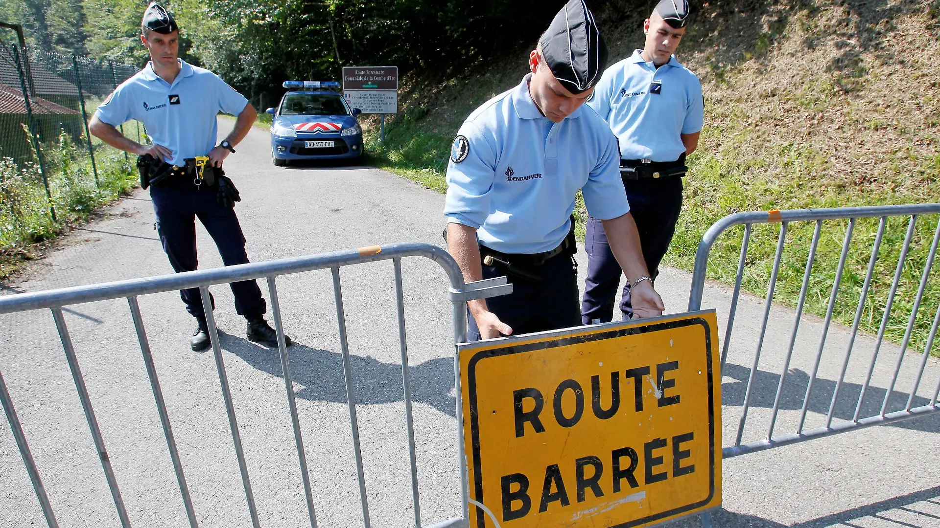 FILE PHOTO: French gendarmes block access to a road to La Combe d'Ire in Chevaline near Annecy, southeastern France, September 6, 2012. REUTERS/Robert Pratta (FRANCE - Tags: CRIME LAW)/File Photo