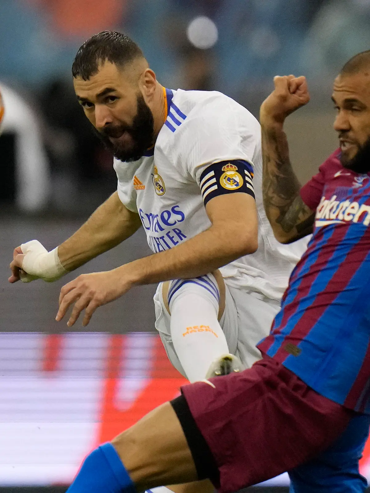 12.01.2022, Saudi-Arabien, Riad: Fußball: Supercup, Spanien, Halbfinale, FC Barcelona - Real Madrid, König-Fahd-Stadion. Karim Benzema (M.) von Real Madrid schießt an Barcelonas Dani Alves (r) vorbei. Foto: Hassan Ammar/AP/dpa +++ dpa-Bildfunk +++