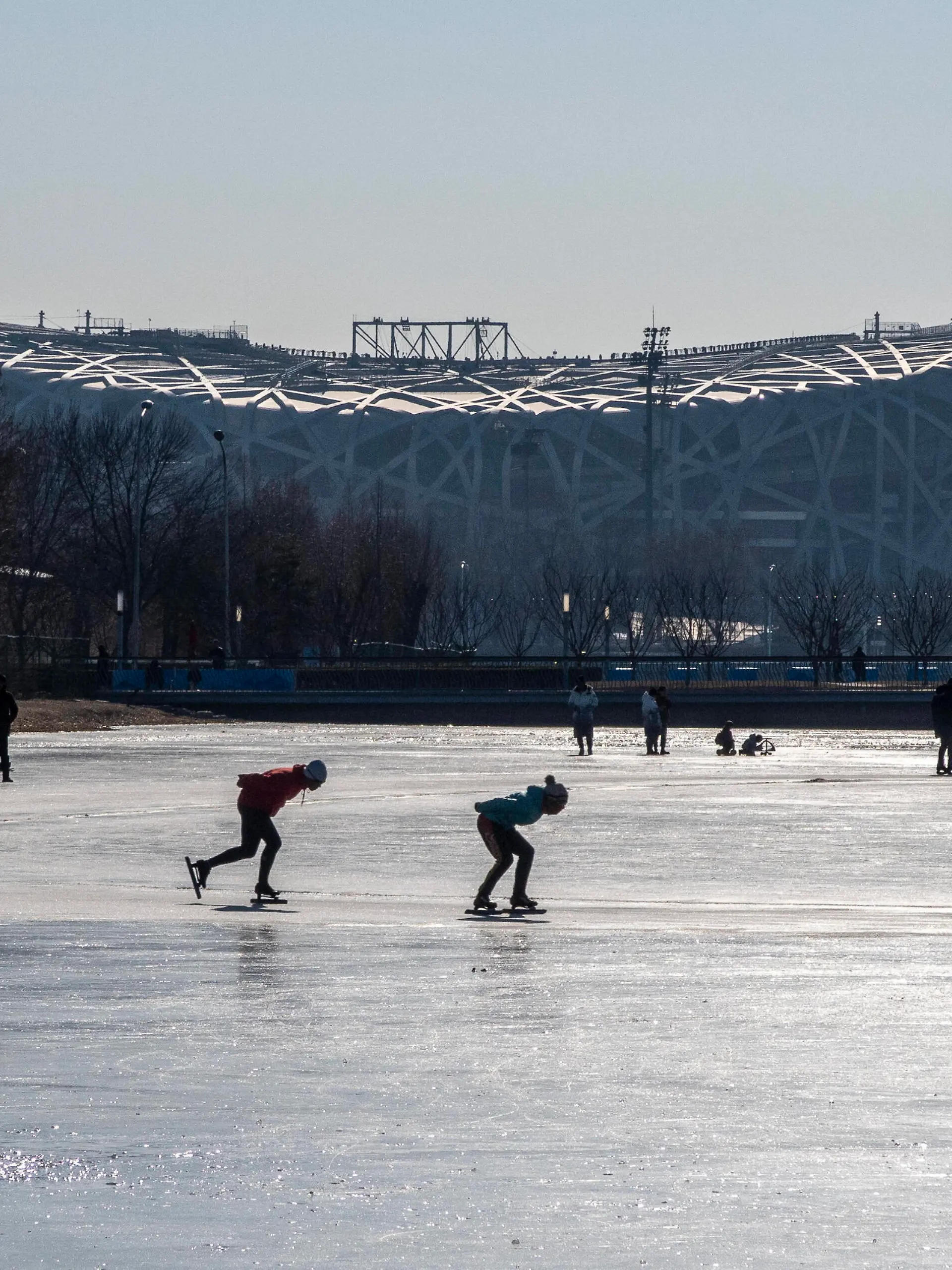  January 6, 2022, Beijing, Hebei, China: Skaters skate on a frozen lake next to the Nest, National Stadium, the venue to hold the opening ceremony of the Winter Olympic Games, Olympische Spiele, Olympia, OS in Beijing, China. Beijing China - ZUMAw80_ 20220106_zaf_w80_008 Copyright: xWiktorxDabkowskix