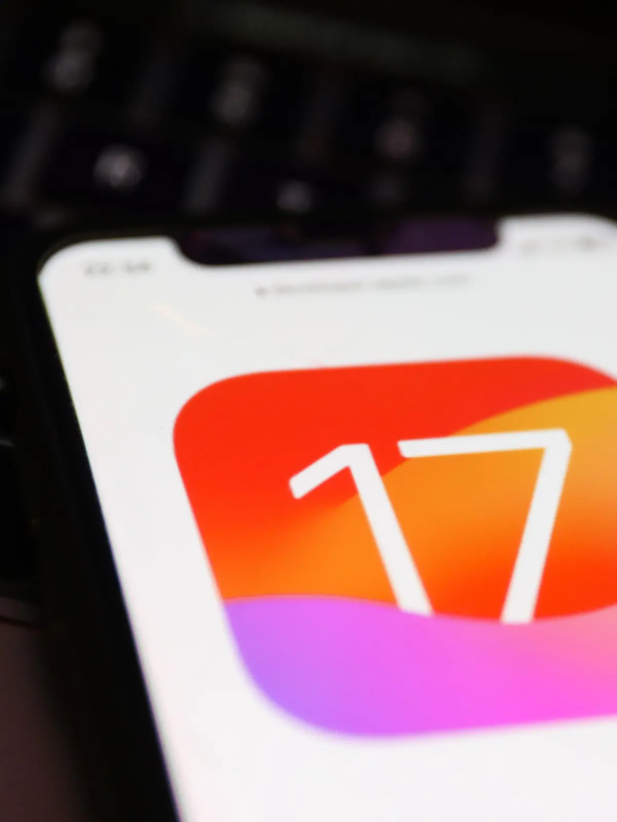 A laptop keyboard and Apple iOS 17 logo on a website displayed on a phone screen are seen in this illustration photo taken in Krakow, Poland on June 6, 2023. (Photo by Jakub Porzycki/NurPhoto)