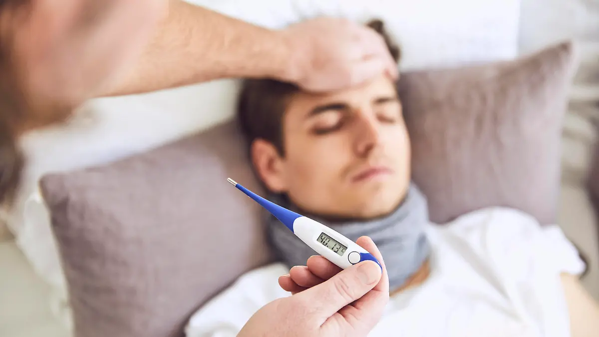  Close-up of doctor examining patient s temperature sleeping on bed at home model released Symbolfoto property released UKOF00029