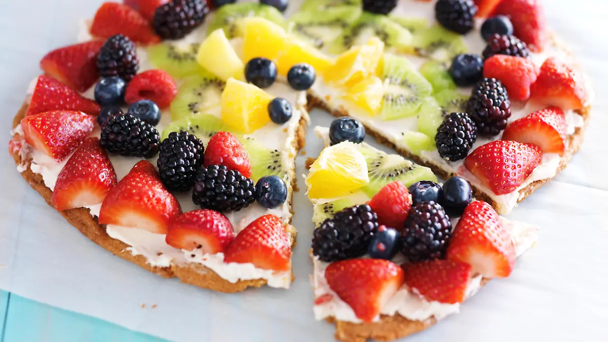 colorful fruit pizza with berries and cream cheese on cookie crust