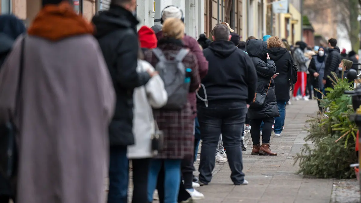 10.01.2022, Berlin: Zahlreiche Menschen warten in einer langen Schlange auf ihren PCR-Test in einem landeseigenen Testzentrum in der Neuköllner Leinestraße. In Berlin bieten die landeseigenen Testzentren kostenfreie PCR-Tests für bestimmte Personengruppen an. Foto: Monika Skolimowska/dpa-Zentralbild/dpa +++ dpa-Bildfunk +++