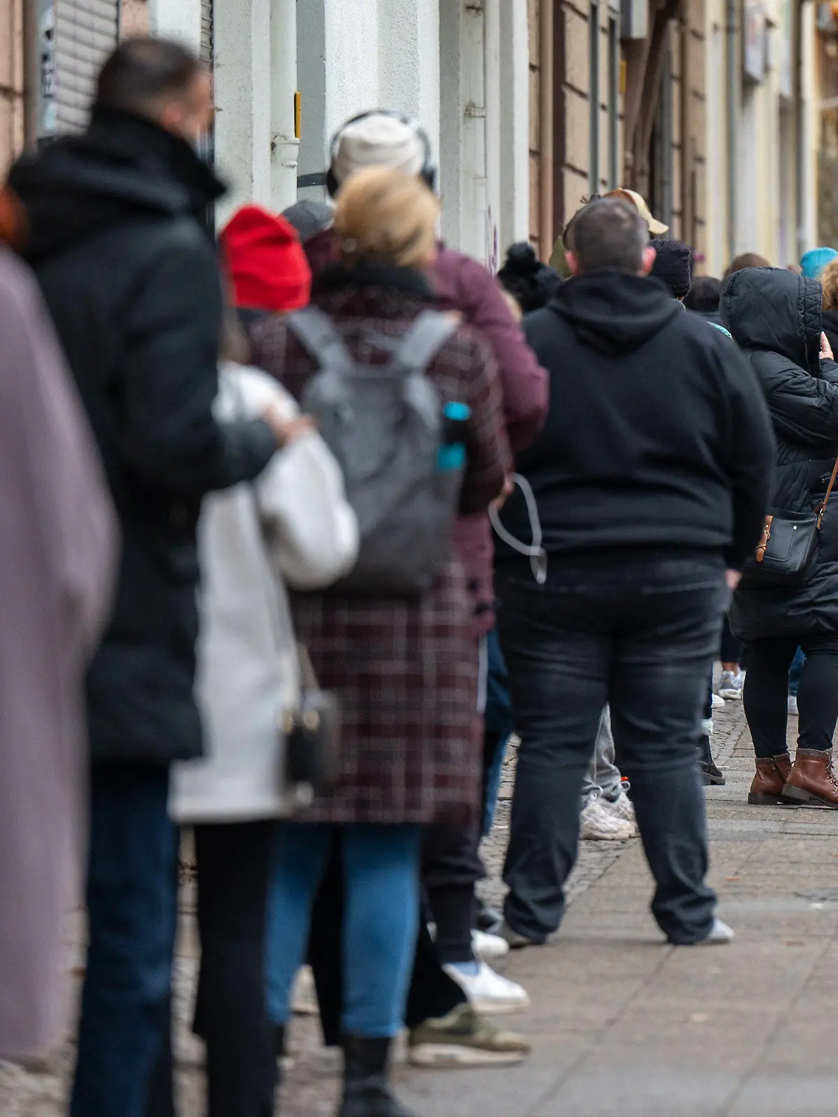 10.01.2022, Berlin: Zahlreiche Menschen warten in einer langen Schlange auf ihren PCR-Test in einem landeseigenen Testzentrum in der Neuköllner Leinestraße. In Berlin bieten die landeseigenen Testzentren kostenfreie PCR-Tests für bestimmte Personengruppen an. Foto: Monika Skolimowska/dpa-Zentralbild/dpa +++ dpa-Bildfunk +++