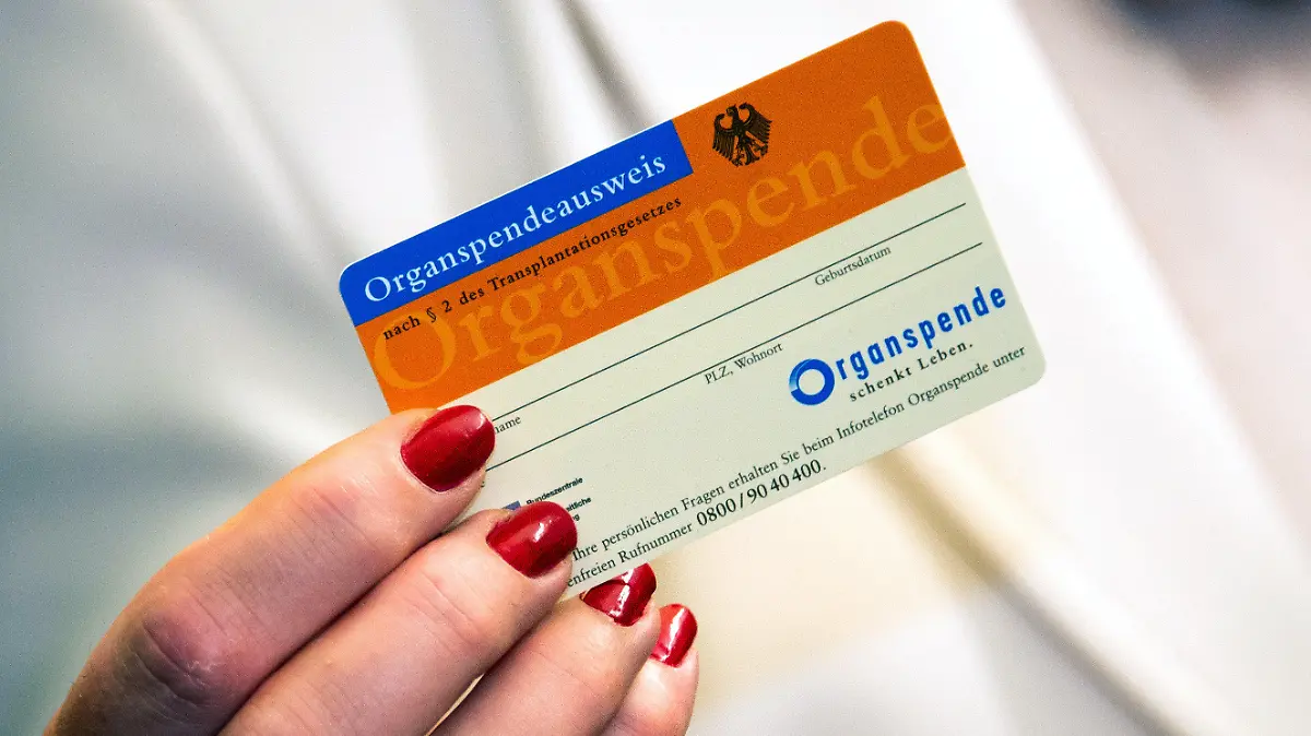 ARCHIV - 01.06.2018, Schleswig-Holstein, Kiel: Eine Frau zeigt im Universitätsklinikum Schleswig-Holstein einen Organspendeausweis. (zu dpa «Norden bei Organspenden weit hinten») Foto: Axel Heimken/dpa +++ dpa-Bildfunk +++
