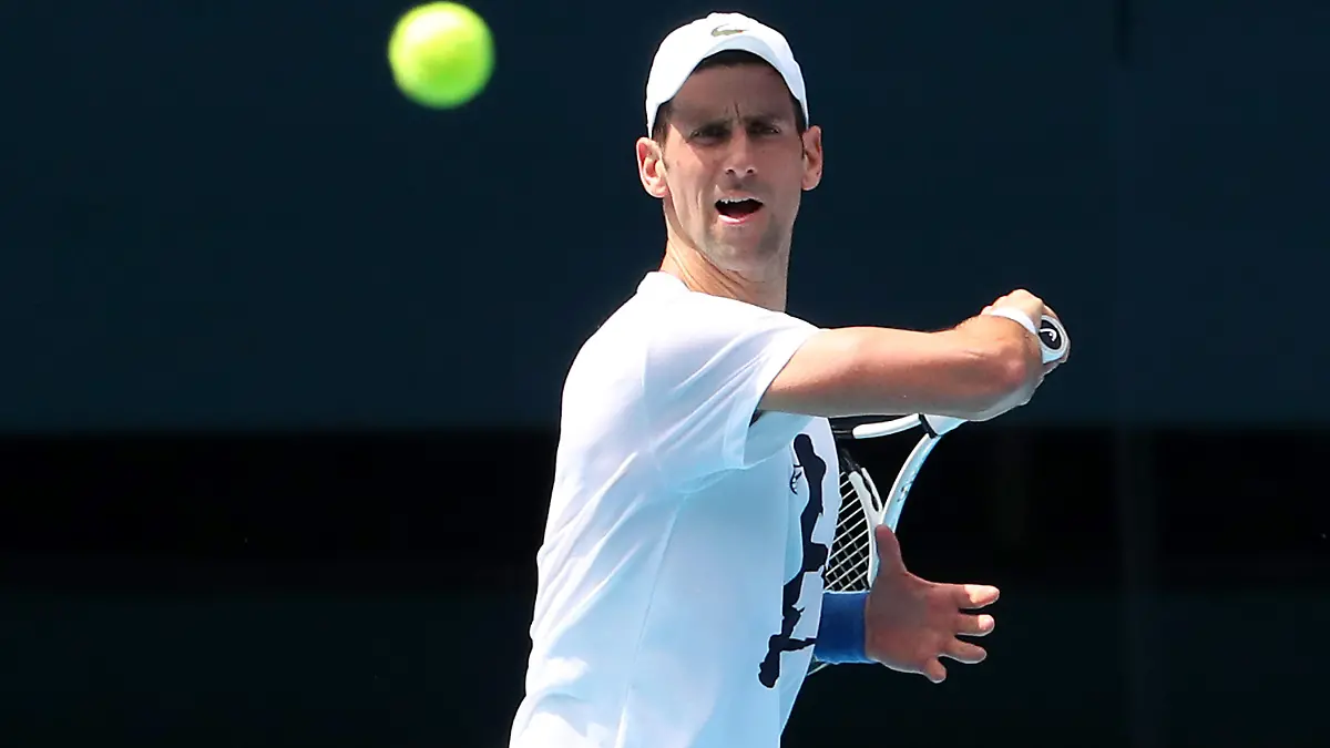 MELBOURNE, AUSTRALIA - JANUARY 11: Novak Djokovic of Serbia practices on Rod Laver Arena ahead of the 2022 Australian Open at Melbourne Park on January 11, 2022 in Melbourne, Australia. Djokovic arrived in Melbourne on Thursday night to play in the upcoming Australian Open and was denied entry to Australia due to his inability to meet Australian entry requirements. He was sent to an immigration detention hotel while the decision to cancel his visa was reviewed in the Australian Federal Circuit Court. Djokovic was granted permission to enter Australia on Monday night and resumed practising soon after with another session this afternoon, while the Federal Government decides if they should still cancel his visa. (Photo by Kelly Defina/Getty Images)