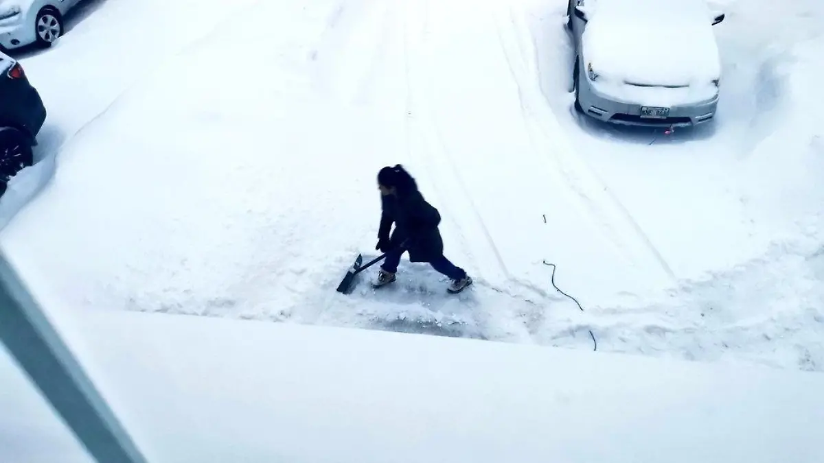 Frau schippt Schnee