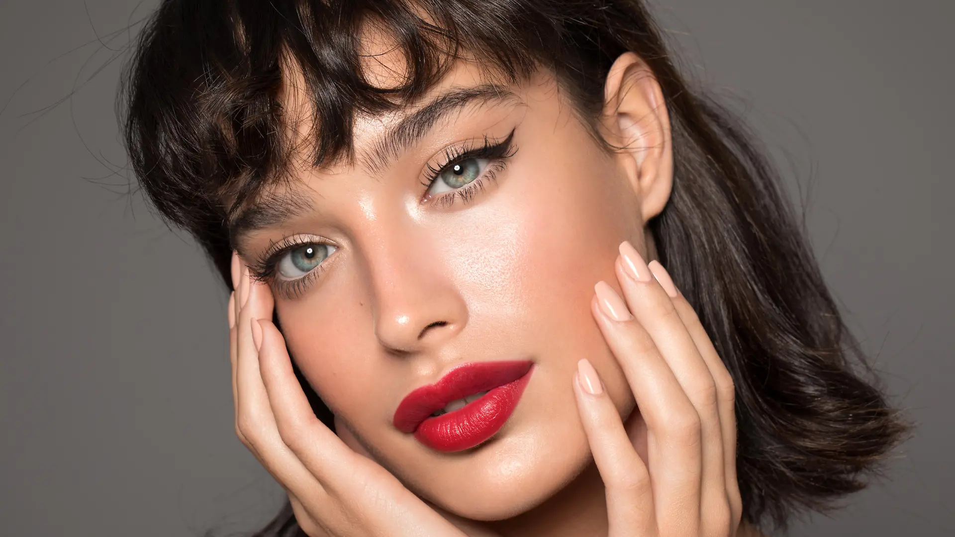 Close up studio shot of a beautiful woman with perfect skin, she touching her face