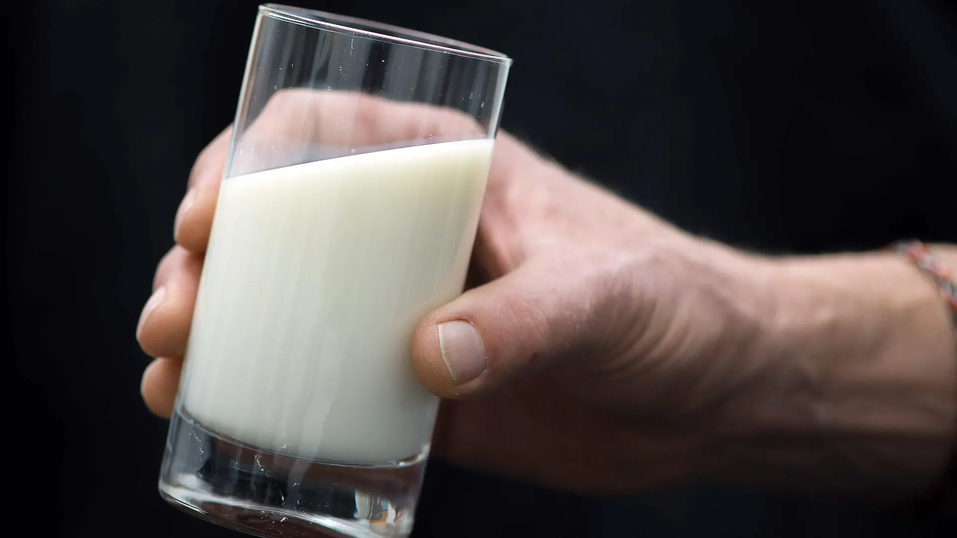 ARCHIV - ILLUSTRATION - 18.02.2016, Hamburg: Ein Mann hält ein Glas Milch in der Hand. (Zu dpa "Milchpreise sinken deutlich") Foto: Lukas Schulze/dpa +++ dpa-Bildfunk +++