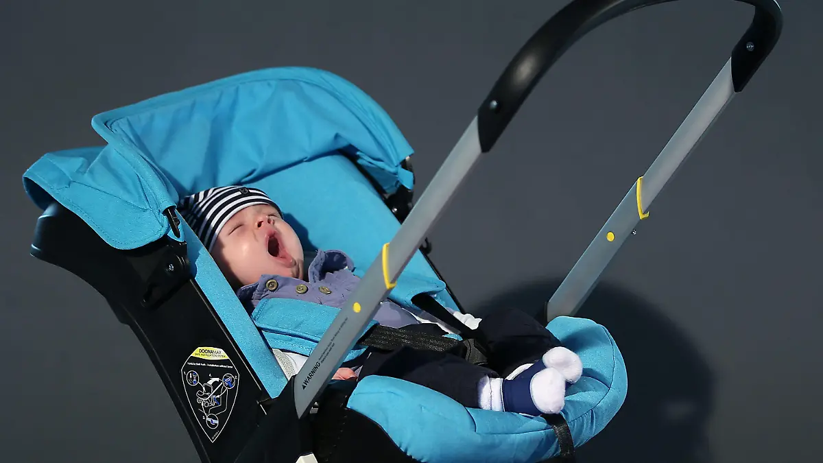 Ein Baby gähnt am 04.09.2014 in Köln (Nordrhein-Westfalen) im Kinderbuggy "doona". Die weltgrößte Messe für Kinderausstattung «Kind+Jugend» ist vom 11.-14.9.2014 in Köln zu sehen. Foto: Oliver Berg/dpa +++(c) dpa - Bildfunk+++