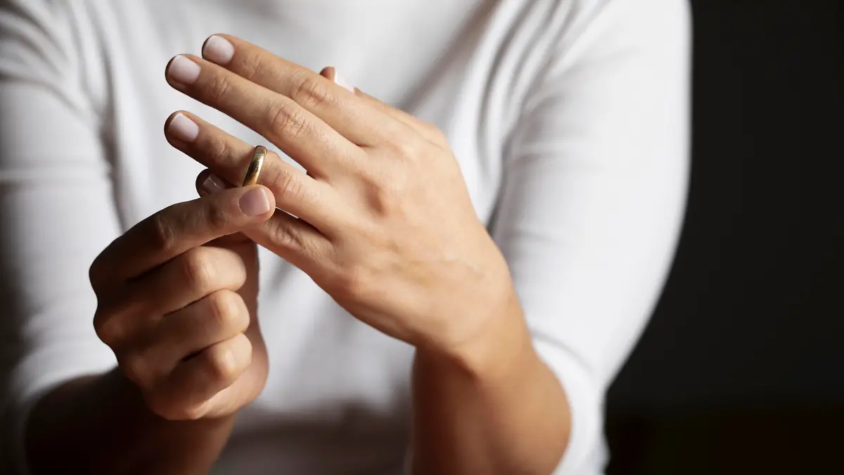 Hands of caucasian female who is about to taking off her wedding ring.